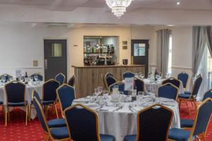 ein Konferenzraum mit Tischen und Stühlen und einer Bar in der Unterkunft Best Western Claydon Hotel in Ipswich