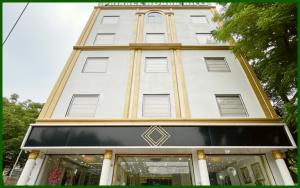 wysoki biały budynek ze złotymi wykończeniami w obiekcie HOTEL - P & D - PALACE Near Kashi Vishwanath Temple - Fully Air Conditioning With Free Wi-Fi Facilities - BEST HOTEL IN VARANASI w mieście Rāmnagar