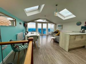 un soggiorno con divano e una cucina con finestre di Seaside Escape in Westward Ho! 3-Bed Family Holiday Home with Sea Views a Westward Ho
