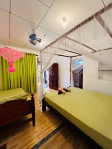 a bedroom with two beds with green and white at Ancient Tree in Mirissa