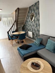 un soggiorno con un divano e un tavolo di Maison cosy & calme a Saint-Florentin