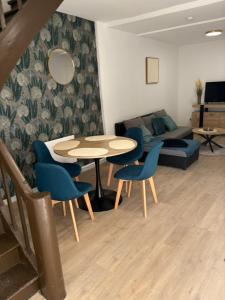 un soggiorno con tavolo, sedie e divano di Maison cosy & calme a Saint-Florentin