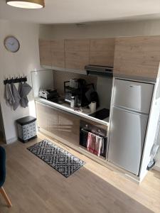 una cucina con un frigorifero in acciaio inossidabile in una stanza di Maison cosy & calme a Saint-Florentin Altre 5 foto