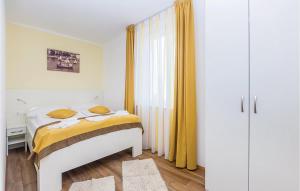 una camera da letto con letto e tende gialle di 2 Bedroom Awesome Apartment In Punat a Punat