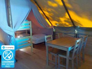 Zelt mit Tisch, Bett, Tisch und Stühlen in der Unterkunft Camping 3 étoiles - efaicg in Auxonne