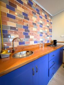 a kitchen counter with a sink and a brick wall at Cabañas Anahuac II in Puerto Montt