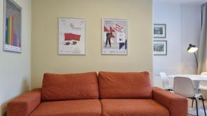 a couch in a living room with posters on the wall at Campo Marzio 6 in Trieste