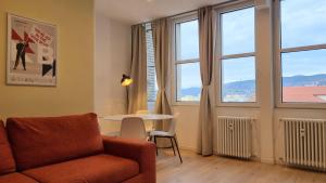 un soggiorno con divano, tavolo e finestre di Campo Marzio 6 a Trieste Altre 24 foto