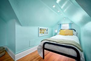 a bedroom with blue walls and a bed with a yellow pillow at Capitol-Side • Downtown • Attic Harry-Potter Door in Cheyenne