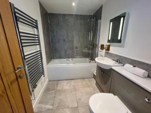un bagno con un water, una vasca e un lavandino di Seaside Escape in Westward Ho! 3-Bed Family Holiday Home with Sea Views a Westward Ho Altre 36 foto