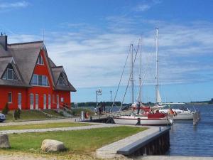a boat is docked next to a red house at Seestern in Neuenkirchen auf Rugen
