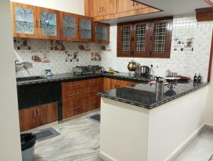 a kitchen with wooden cabinets and a black counter top at EnDai House - Kalyanpuri, Uppal in Hyderabad