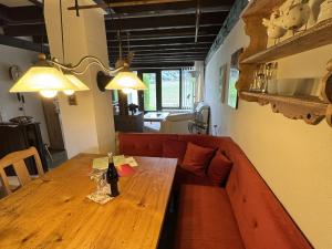 een woonkamer met een houten tafel en een rode bank bij Ferienhaus Hochtal in Altenrond