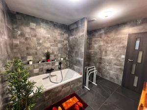ein Badezimmer mit Badewanne und Dusche in der Unterkunft Chambre CLAIRIERE in Maizières-lès-Metz