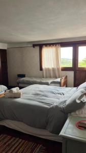 a large bed in a bedroom with a window at Hostel Cumbrecita Planeta in La Cumbrecita +42 photos