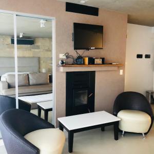 a living room with two chairs and a fireplace at Apart Spa Linda Bay in Mar de las Pampas