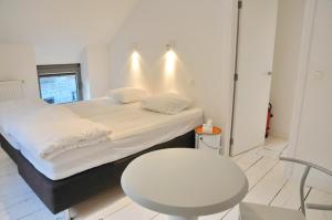 a bedroom with a bed and a table and a chair at L'atelier de Durbuy in Durbuy