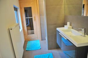 a bathroom with a sink and a shower with blue towels at L'atelier de Durbuy in Durbuy +13 photos