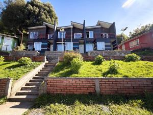 a large house with stairs in front of it at Cabañas Anahuac II in Puerto Montt