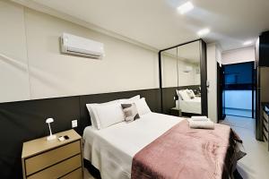 a bedroom with a large white bed and a mirror at Studio Pérola – Conforto, modernidade prox a UFU! in Uberlândia +29 photos