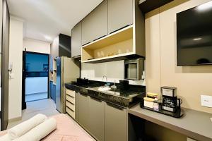 a kitchen with a sink and a refrigerator at Studio Pérola – Conforto, modernidade prox a UFU! in Uberlândia