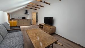 salon z kanapą, telewizorem i stołem w obiekcie Penthouse 2 , apartment with 2 bedrooms w mieście Dilidżan +17 zdjęć