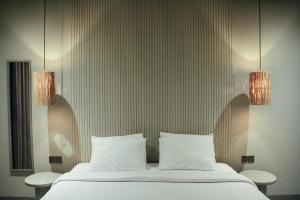 ein Schlafzimmer mit einem Bett mit zwei Lampen darüber in der Unterkunft Greywood in Gili Trawangan