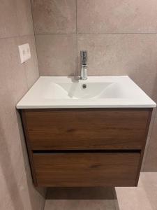a white sink in a bathroom with a mirror at Beachhouse Noteboom, omheinde tuin in Noordwijk aan Zee +28 photos