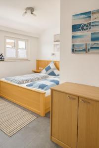 a bedroom with a wooden bed and a window at Fewo Mainau in Unteruhldingen +8 photos