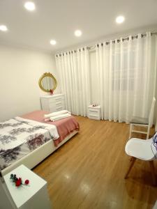 ein Schlafzimmer mit einem Bett, einem Spiegel und einem Tisch in der Unterkunft Serendipity Apartment in Tirana