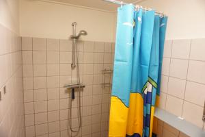 een douche met een blauw douchegordijn in een badkamer bij Kustverhuur, Park Schoneveld Duinroos 131 in Breskens +10 foto's
