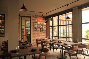 ein Restaurant mit Holztischen und -stühlen und Fenstern in der Unterkunft Greywood in Gili Trawangan