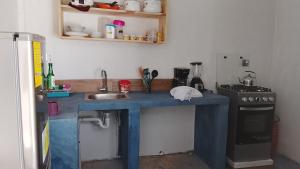 a kitchen with a blue counter with a sink and a stove at Hostel Casa escondida in Santa Cruz La Laguna