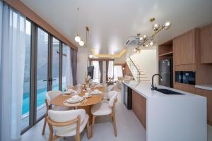 a kitchen and dining room with a table and chairs at 竹光别院 Bamboo Radiance Villa in Ban Thalat Choeng Thale