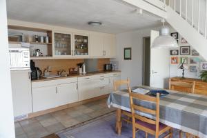 een keuken met witte kasten en een tafel met stoelen bij Kustverhuur, Park Schoneveld Duinroos 131 in Breskens