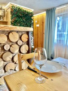 a wine glass sitting on a table with a plate at Guest House Rila in Govedartsi