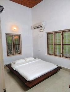 Un pat sau paturi într-o cameră la Maanasam Farmstay - Boutique 3BR Countryside Villa, Manikkadavu