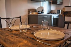una mesa de madera con dos platos y vasos. en Escale Atlantique, en Saint-Nazaire 2 fotos más