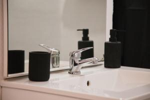 lavabo con grifo y 2 botellas de jabón en Escale Atlantique, en Saint-Nazaire