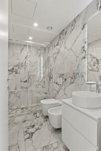 a white bathroom with a sink and a toilet at The Golden Duo Two luxury units in one building by Aura Luxury Collection in Como +33 photos