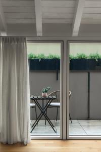 a room with sliding glass doors and a table with a chair at The Golden Duo Two luxury units in one building by Aura Luxury Collection in Como