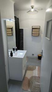 Un baño con un lavabo blanco y un espejo. en Escale Atlantique, en Saint-Nazaire