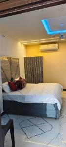 a bed in a room with a blue ceiling at Dev Guest House in Aklera