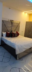 a large bed with pillows on it in a room at Dev Guest House in Aklera