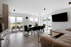 a living room with a table and chairs and a television at Ferienhaus Ebbe in Schülp