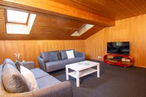 ein Wohnzimmer mit einer Couch, einem Fernseher und einem Tisch in der Unterkunft Im Zentrum OG in Adelboden