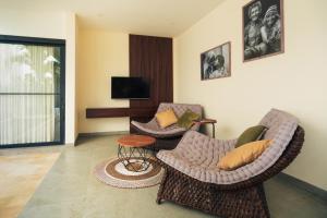 ein Wohnzimmer mit zwei Stühlen und einem Tisch in der Unterkunft Senyum Villa in Canggu