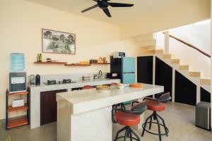 eine Küche mit einer Theke mit Hockern und einem Kühlschrank in der Unterkunft Senyum Villa in Canggu