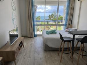 een hotelkamer met een bed en een groot raam bij Soleiade Le Gosier - Accès Plage in Le Gosier