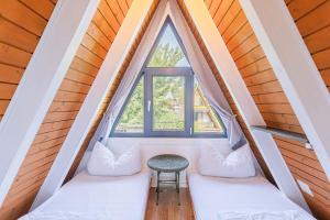 ein Zimmer mit zwei weißen Sofas und einem Fenster in der Unterkunft Ferienwohnpark Immenstaad am Bodensee Nurdachhaus Typ 7 ND 15 in Immenstaad am Bodensee